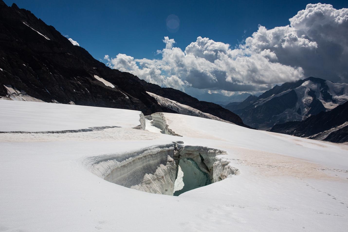 A snow covered mountain with a hole in it

Description automatically generated