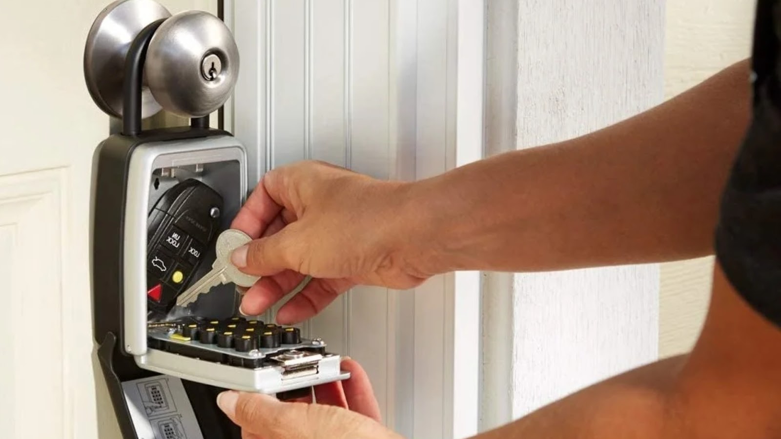 A user storing house and car keys in a key lock box