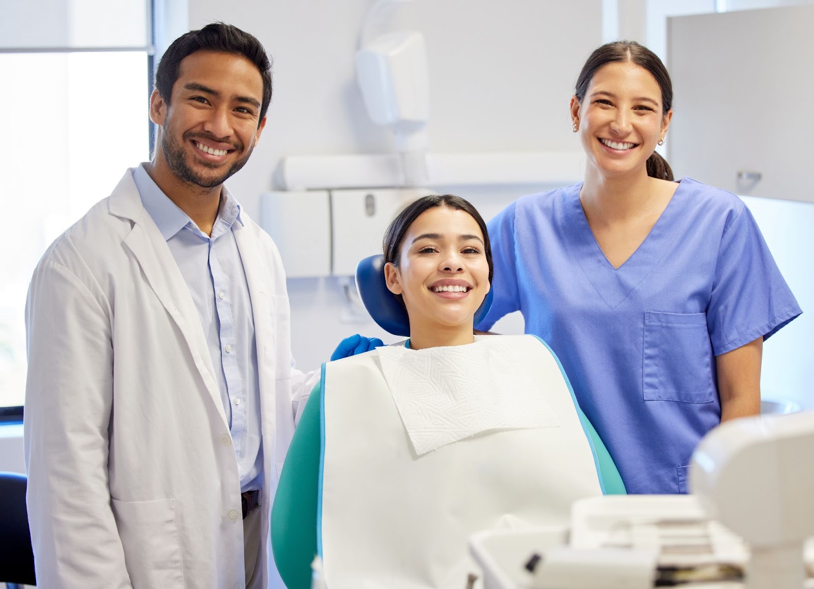 A picture of a woman with a dentist and an assistant during a dental consultation. 