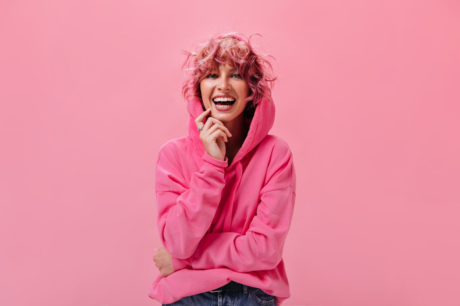 A cheerful girl with vibrant pink hair.
