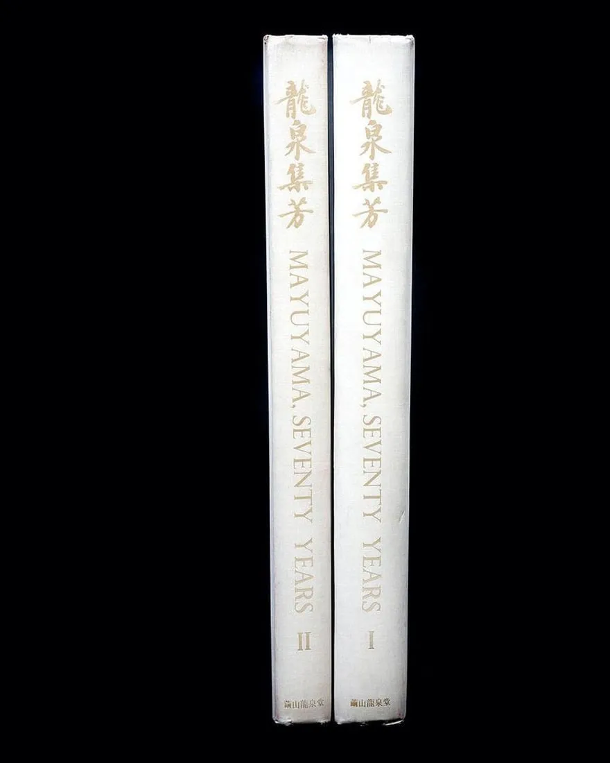 A pair of white books with gold writing on themDescription automatically generated