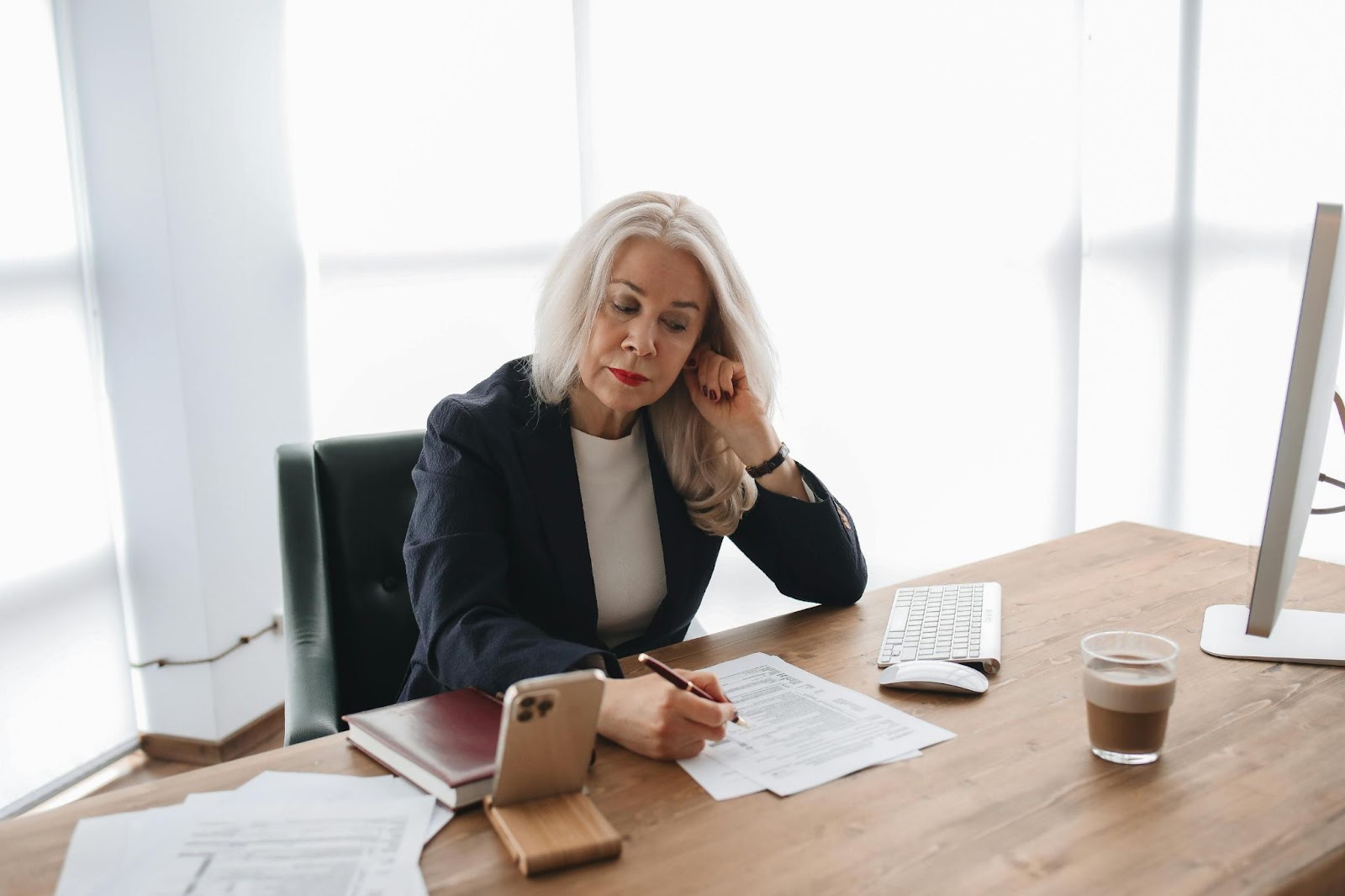 A woman reviewing documents at her desk