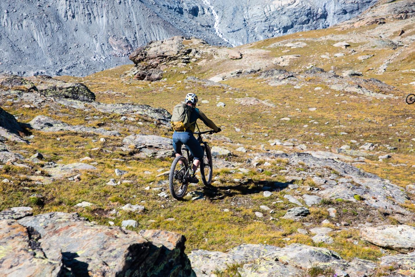 A person riding a bike on a rocky terrain

Description automatically generated