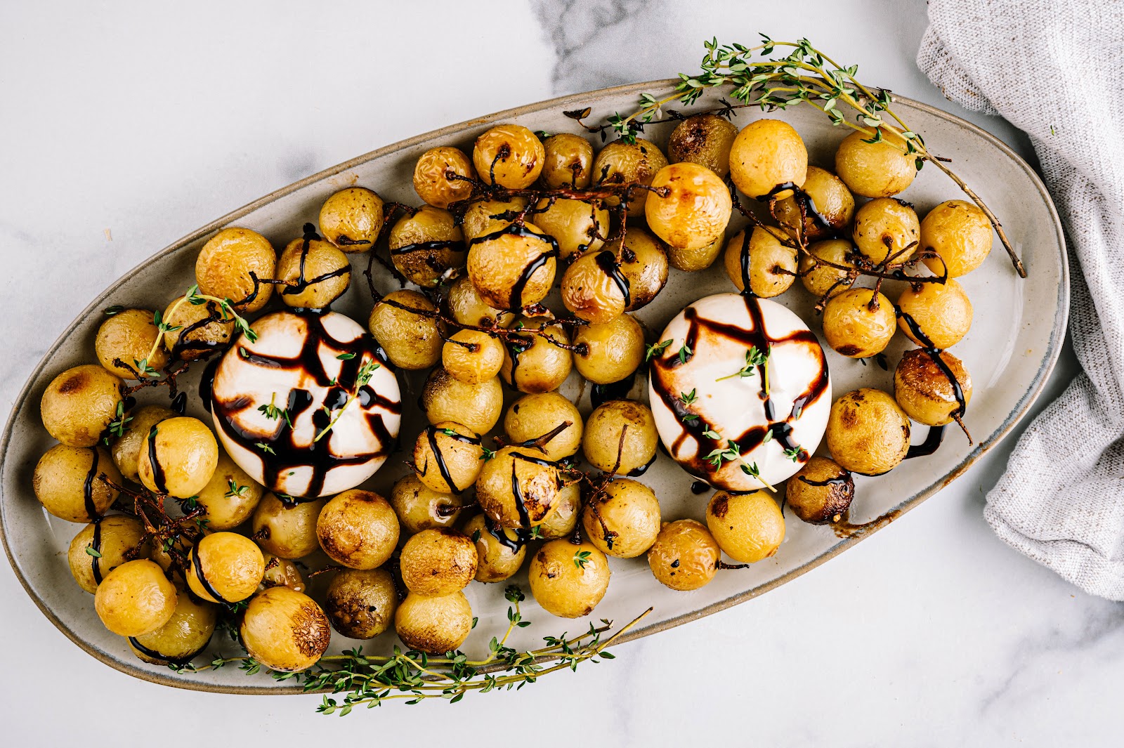 Transfer grapes to a serving plate, place burrata through out, and drizzle with balsamic glaze.