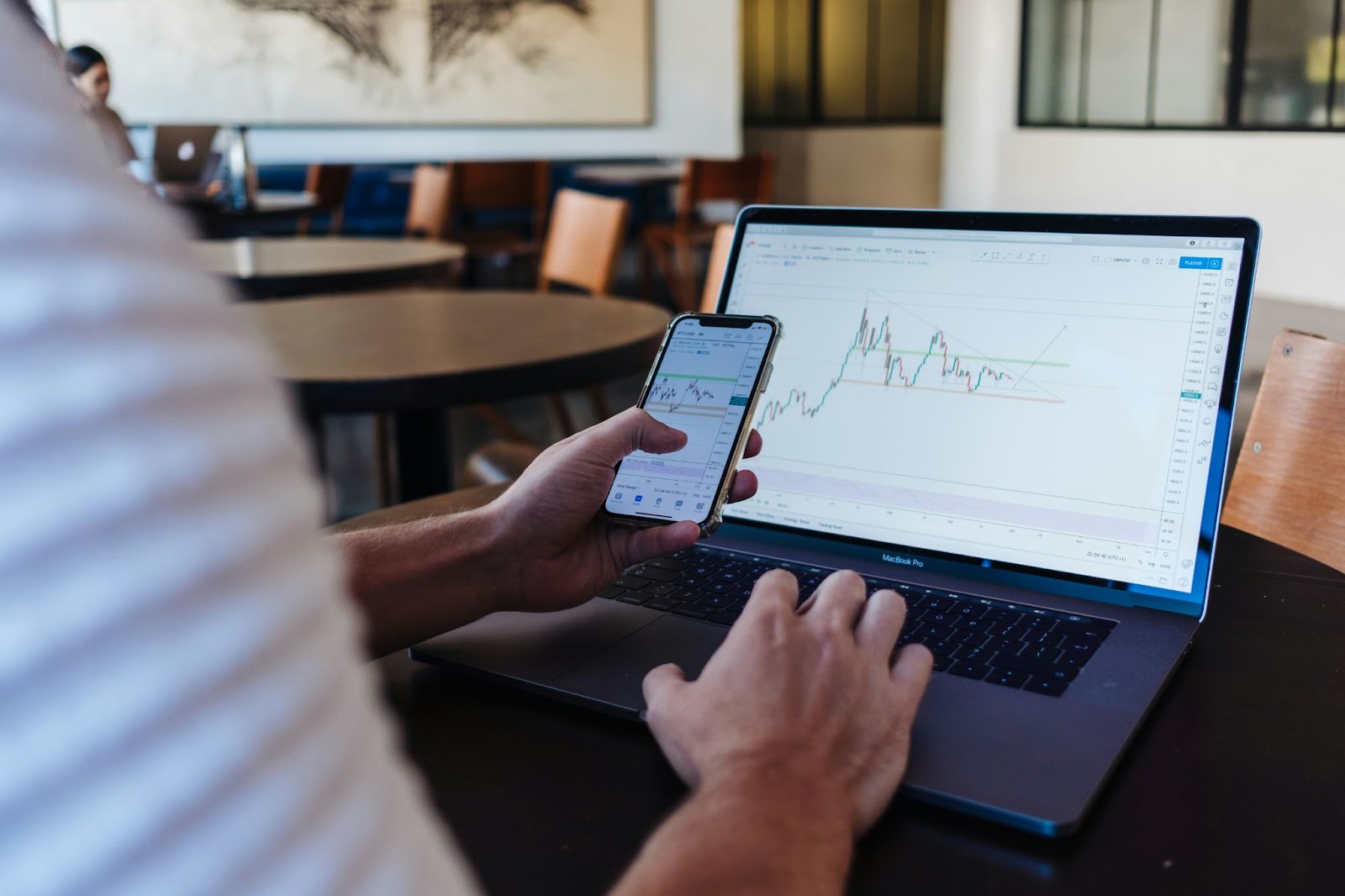 Man analyzing forex trading charts on laptop and mobile