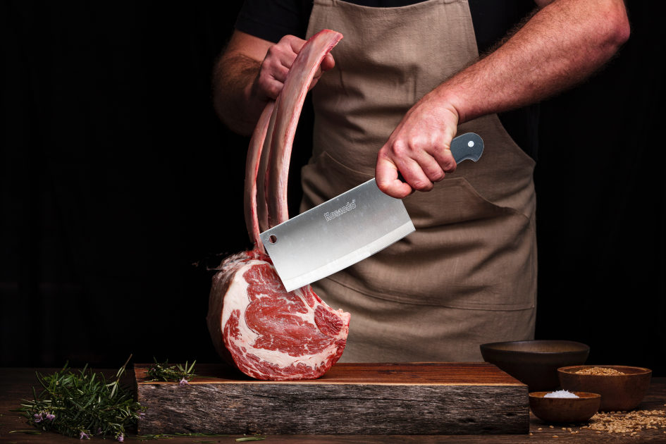 Seorang pria memotong daging dengan pisau.