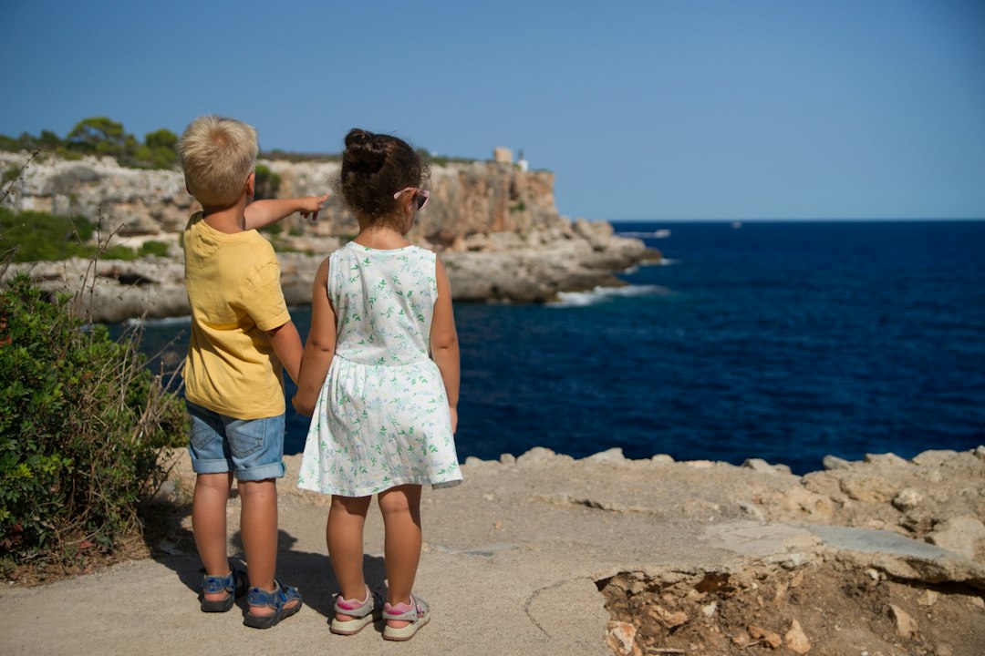 Twee kinderen die naar de zee kijken. 