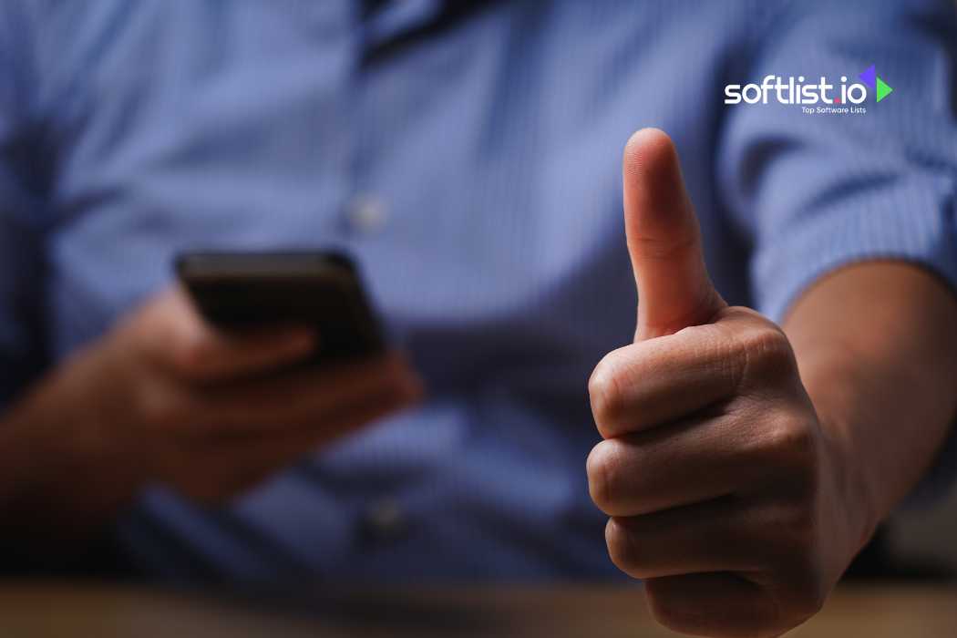 Person giving a thumbs up while holding a smartphone