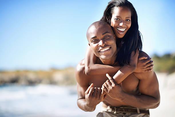 enjoying their vacation in the sun together - young black couple in love stock pictures, royalty-free photos & images
