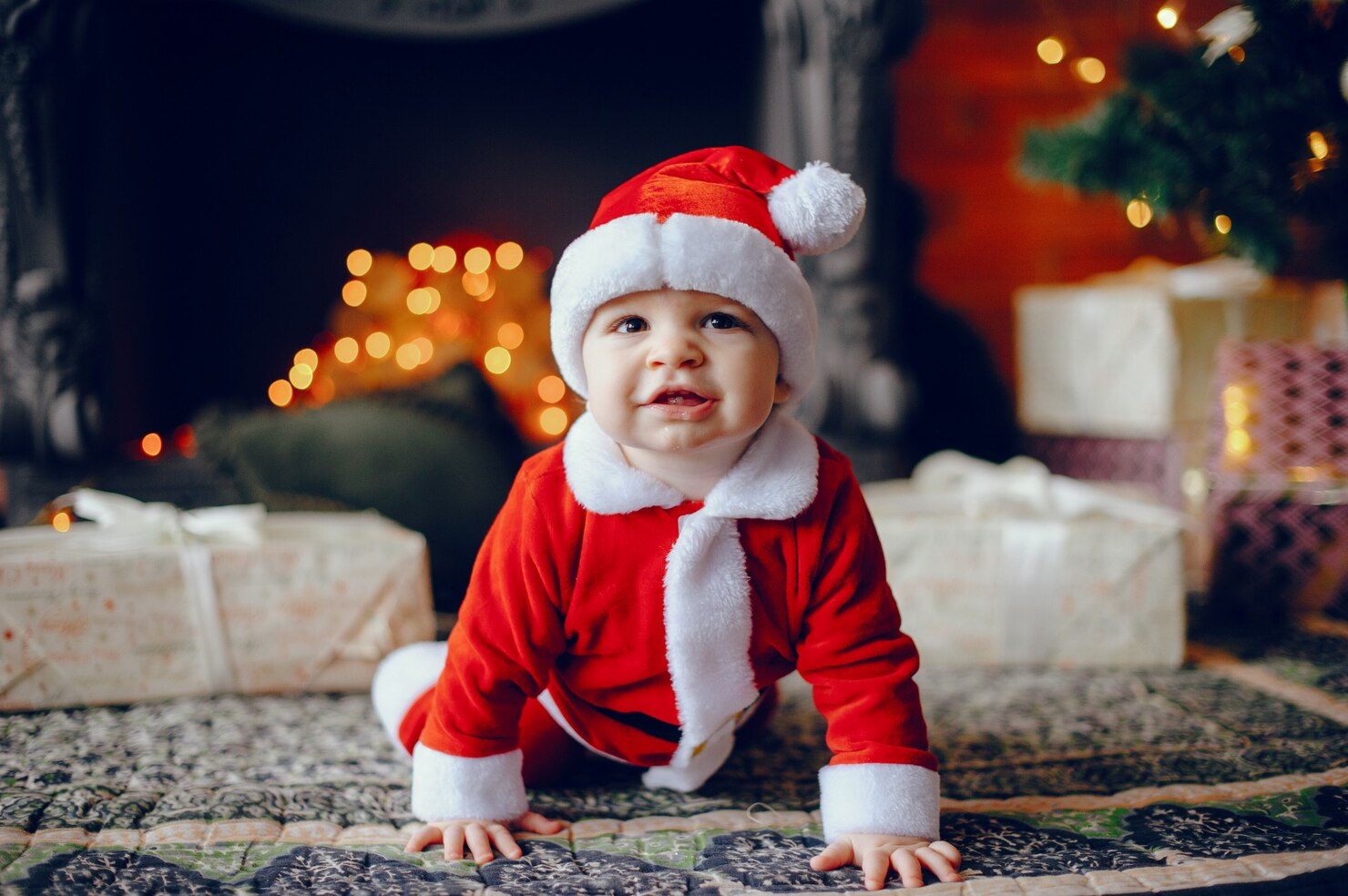 A baby dressed like Santa for Christmas.