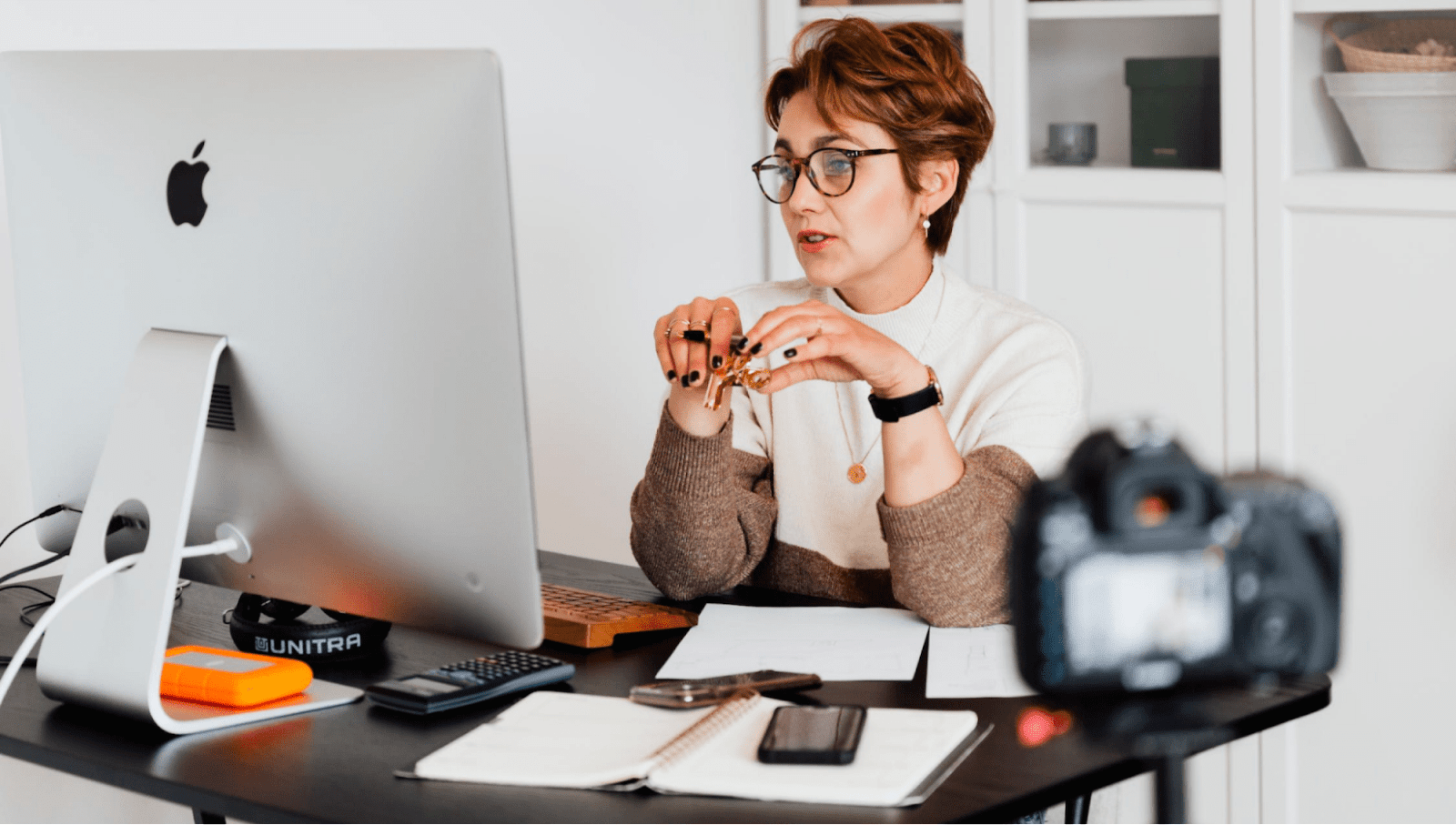 A woman looking at a screen at her desk