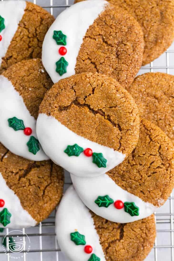 gingersnap cookies dipped in frosting with holly and berries
