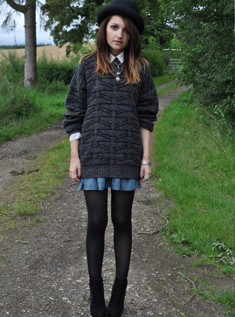 Picture showing a lady pairing her bowler hat with an oversized sweater