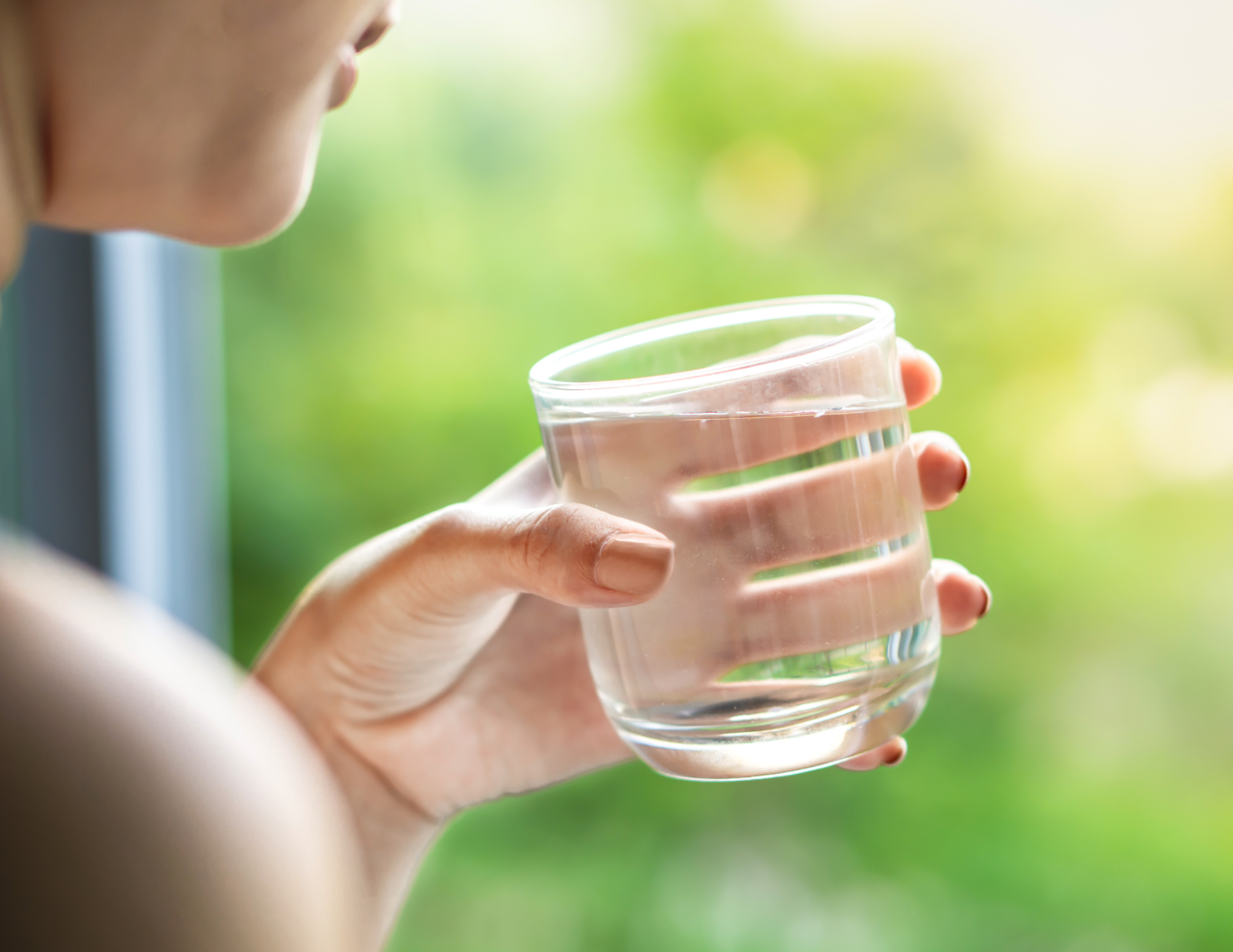 woman drinking water to hydrate and detox