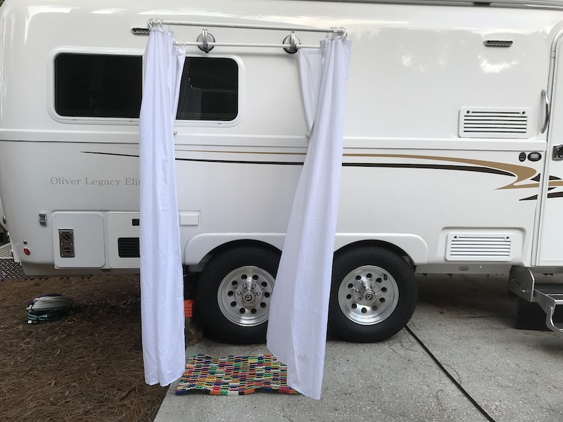 Small travel trailer with shower curtain attached to the side