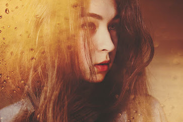Atmospheric double-exposure image of a female model overlayed with textured raindrops