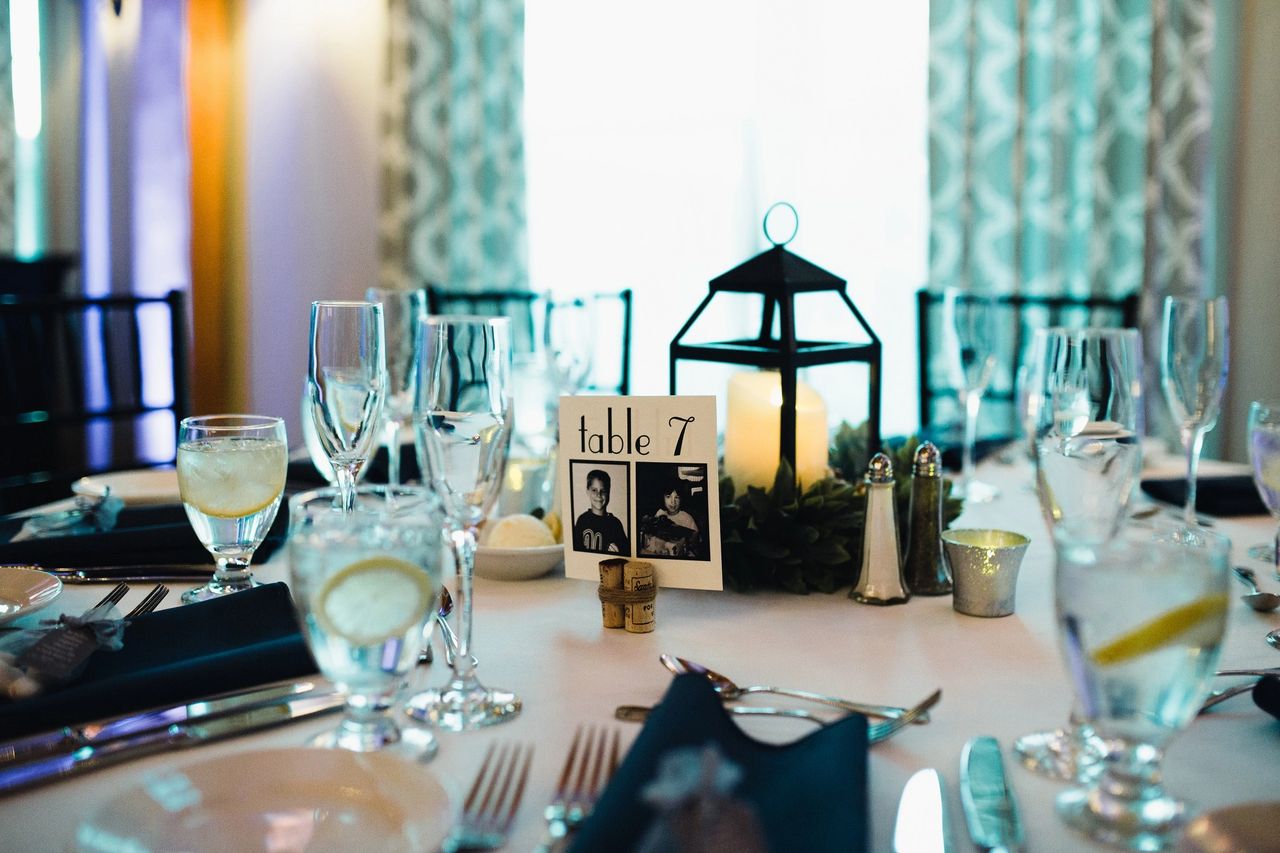 Showcasing table at wedding with decor (black lantern and table cards in middle)
