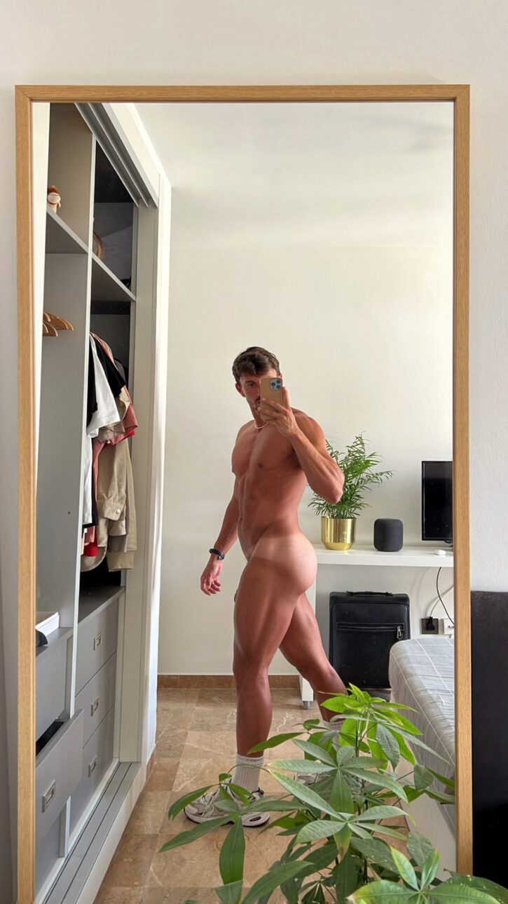 gay xxx onlyfans content creator Eric Rmgr taking a naked mirror selfie with gay bubble butt in frame and showing off the tip of his penis