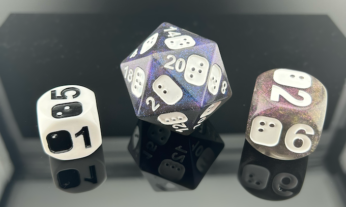 3 Dice models from the Inclusive Dice Series: a single D6 from the white and black D6 Level Up, a single D20 from the Galaxy Dice Set, and a single D6 from the D6 Titans.