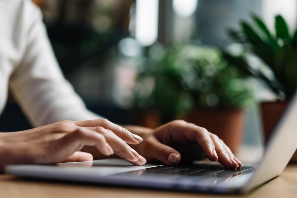 Close-up shot of a pair of hands typing using a laptop