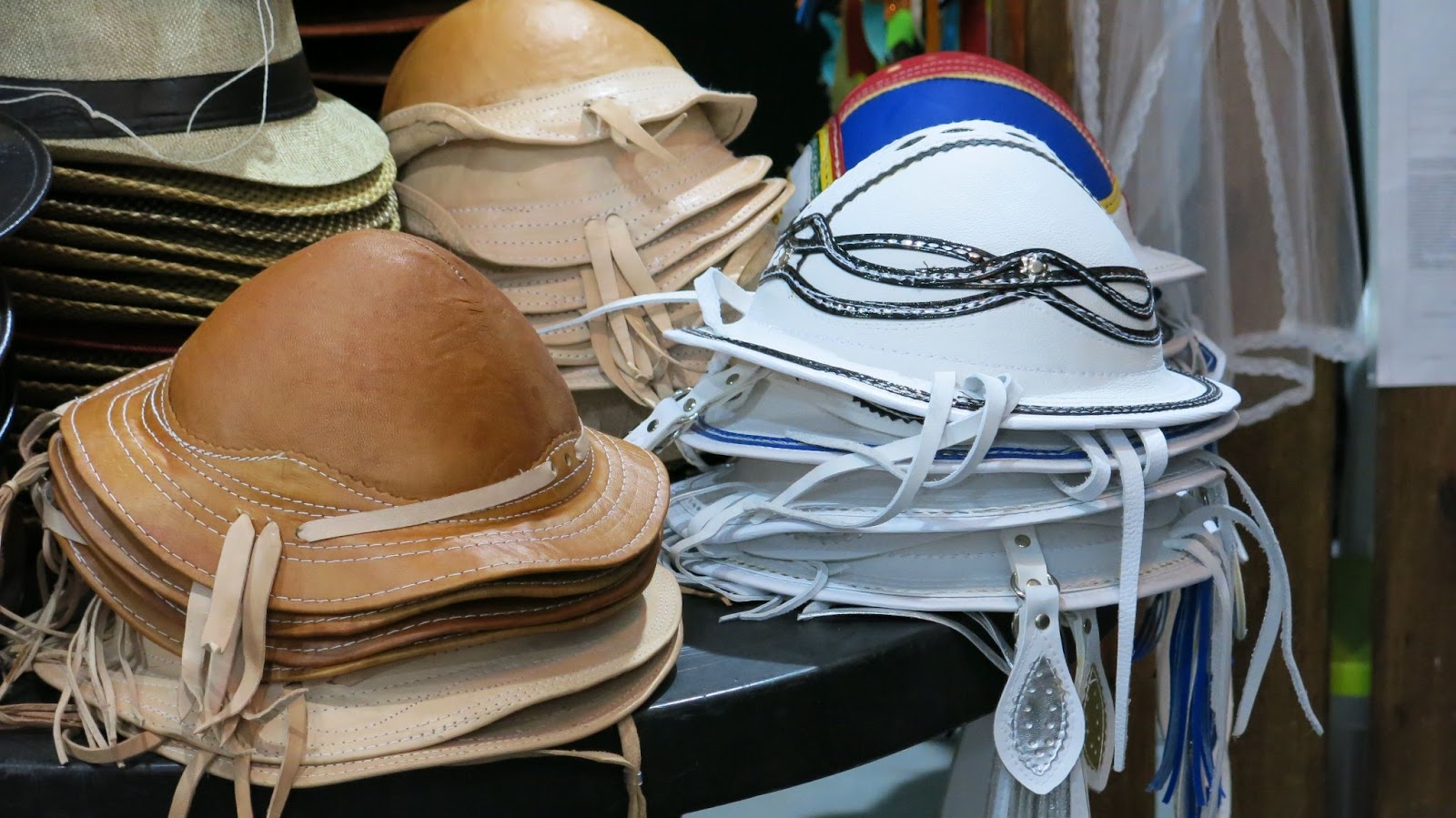 Chapéus de couro, indumentárias tradicionalmente usadas pelos trabalhadores rurais do interior de Pernambuco. Os vários modelos de chapéus estão empilhados sobre o balcão de uma loja.