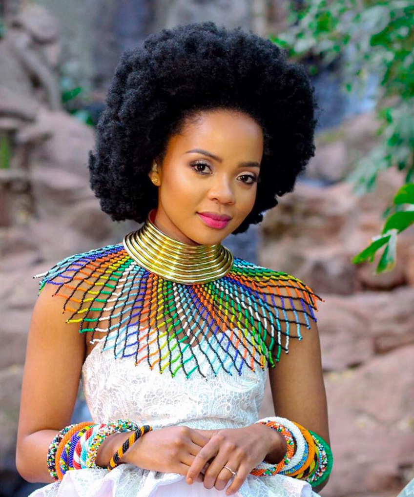 Picture showing an African woman dressed in her traditional attire with her gorgeous 4C curls