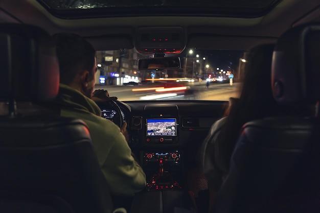 Free photo man and woman in a car at night view from the car