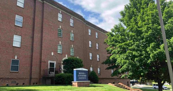 A view of Luntsford Hall, one of the residence halls at East Tennessee State University, with a brown brick exterior and a rectangular shape.