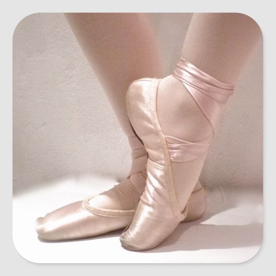 A ballet dancer's lower legs and feet in pretty pink pointe slippers.