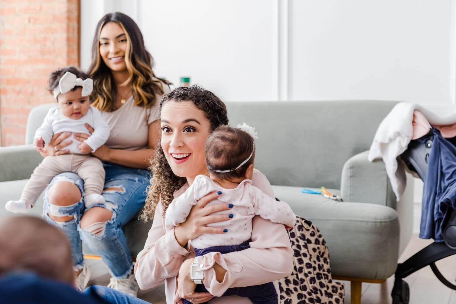 A group of mothers holding their infants while chatting