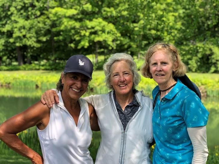 A group of women standing in front of a pond

Description automatically generated