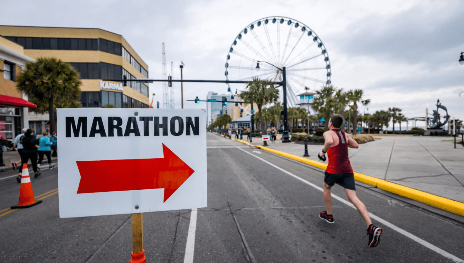 A runner runs past a a47 sign with a red arrow tha says "marathon"