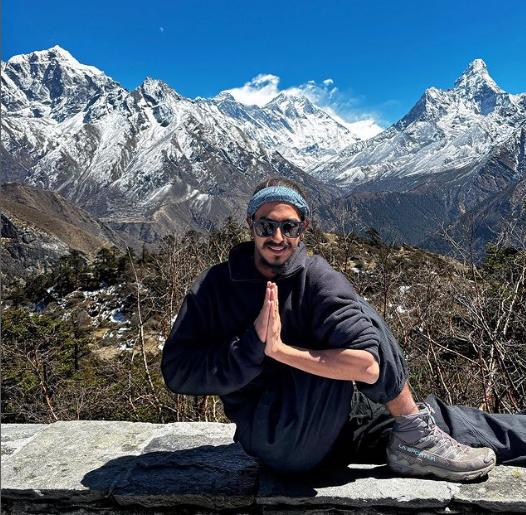 yoga retreat - man posing yoga assan in mountain