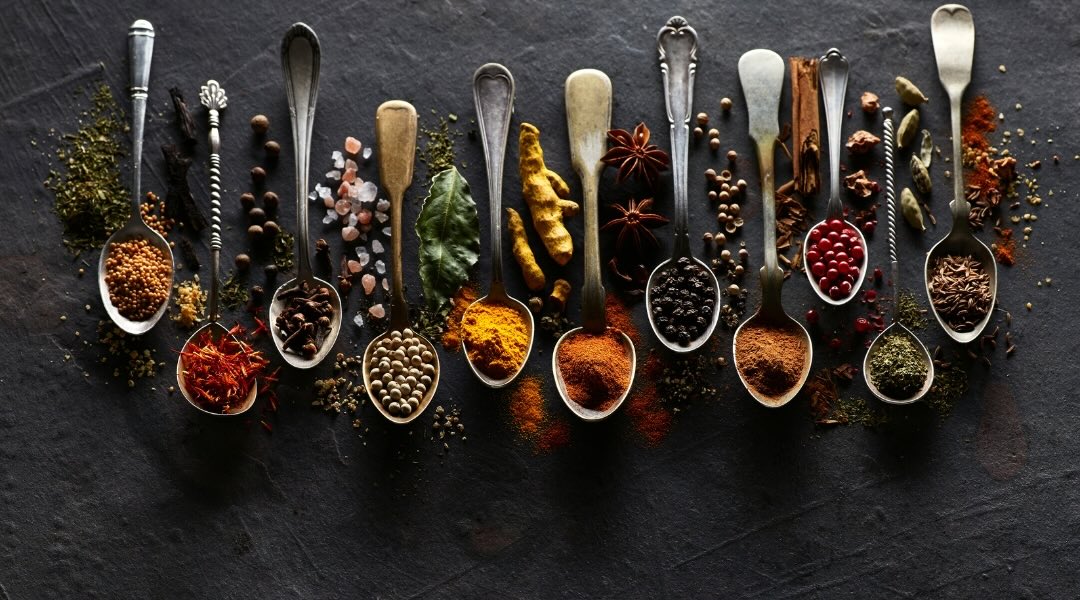 Several spoons of spices on graphite cardboard