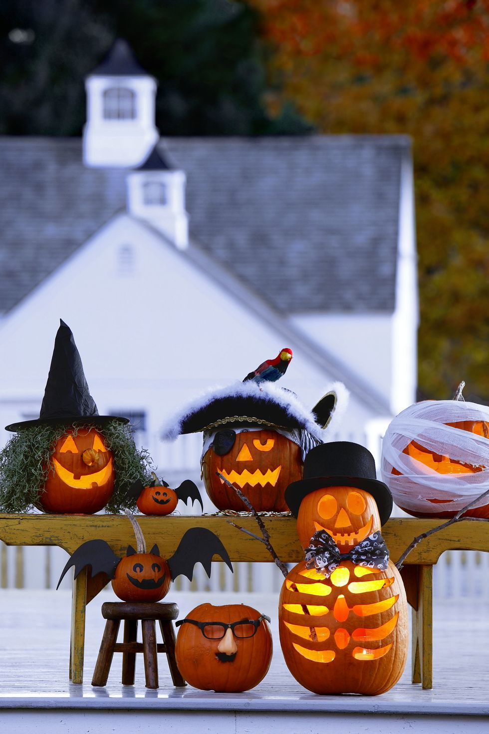 pumpkin carving ideas, six pumpkins with carved scary faces to look like a monster group