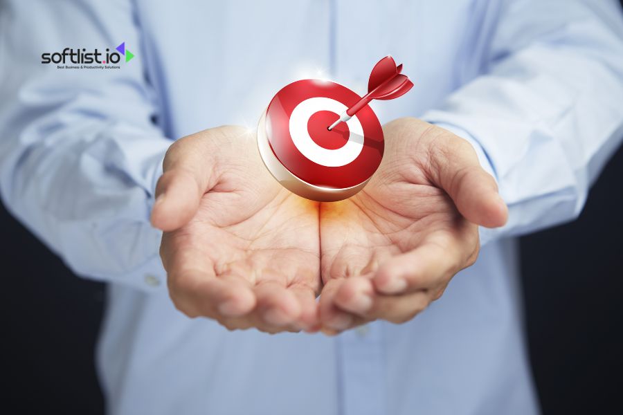 Hand holding a dartboard target, representing business goals and accuracy.