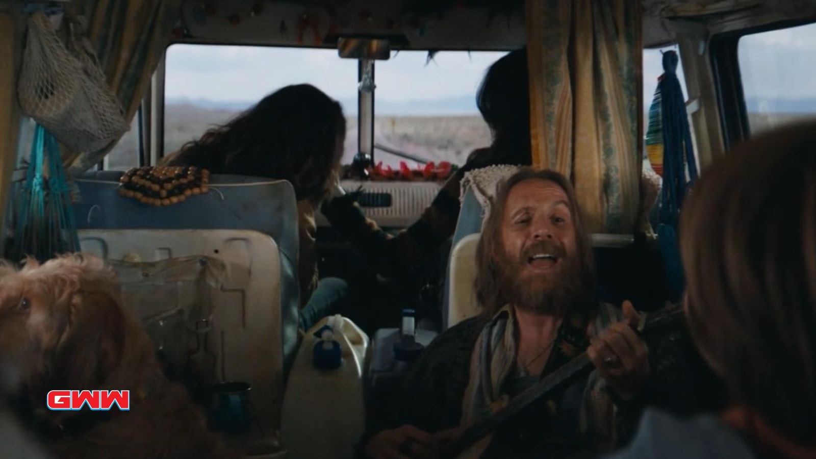 Rhys Ifans singing with a guitar in the back of a van in Venom: The Last Dance