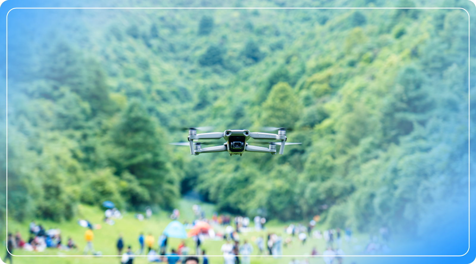 A drone flies above an open-air crowd.