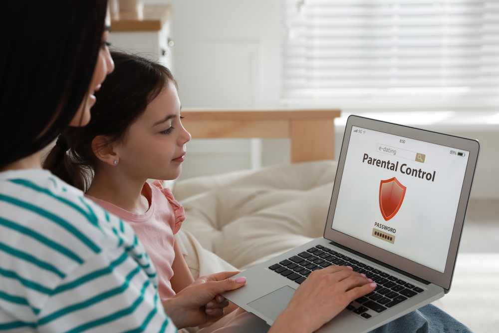 Young girl and her mom setting up parental controls on their computer