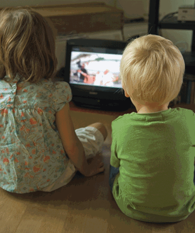 A child and child sitting on the floor watching television

Description automatically generated