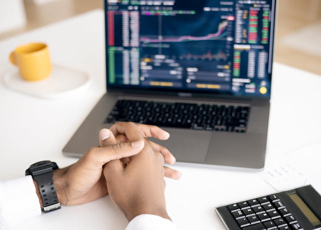 A person analyzing stock market charts on a computer