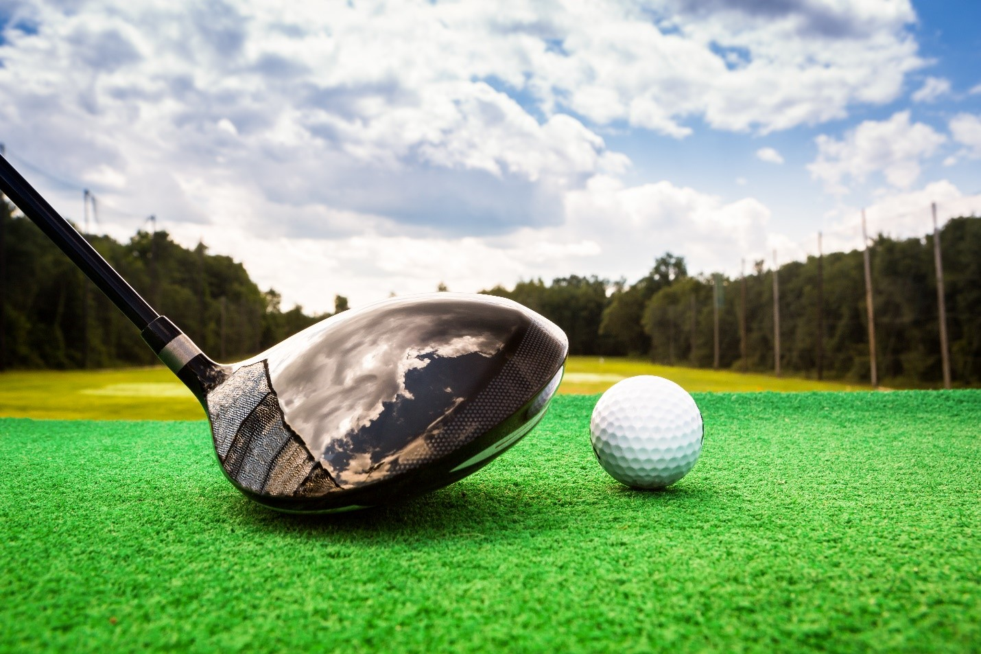 close up shot of a 5 wood driver about to hit a golf ball off the deck with no tee
