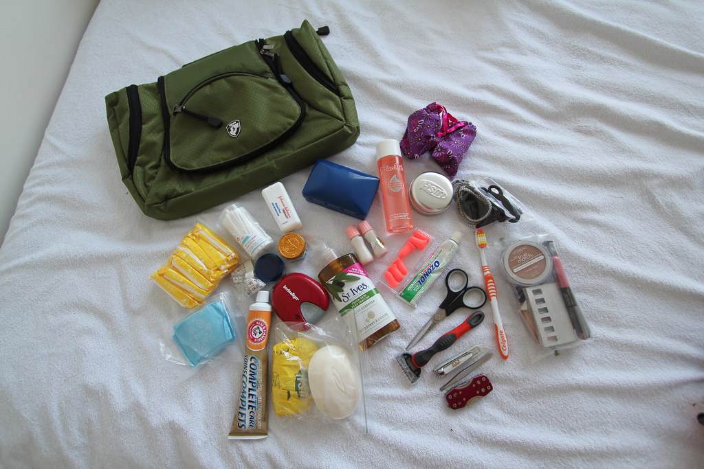 A few toiletry travel essentials like toothpaste, toothbrush, razor, nail cutter, earbuds, scissors, etc alongside the bag that will carry them all.