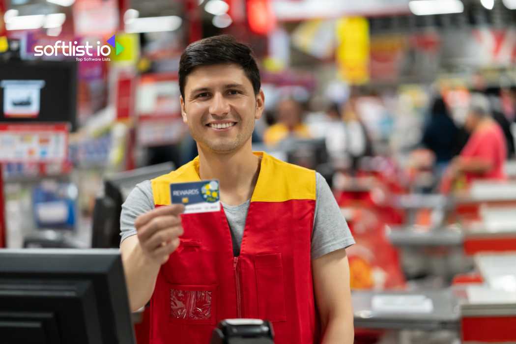 Smiling store employee holding rewards card at the checkout counter