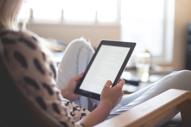 A person reading a material on her tablet.