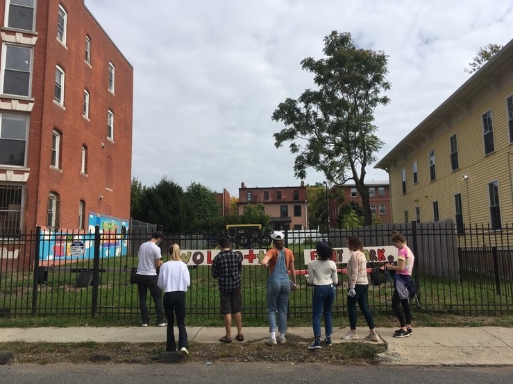 A group of people standing in front of a fence

Description automatically generated