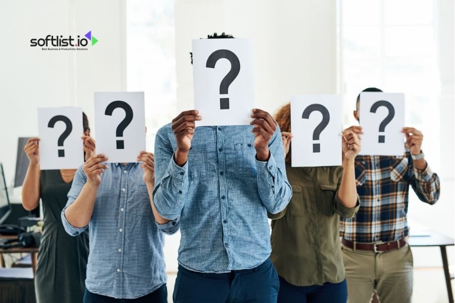 People holding question mark signs in front of faces.