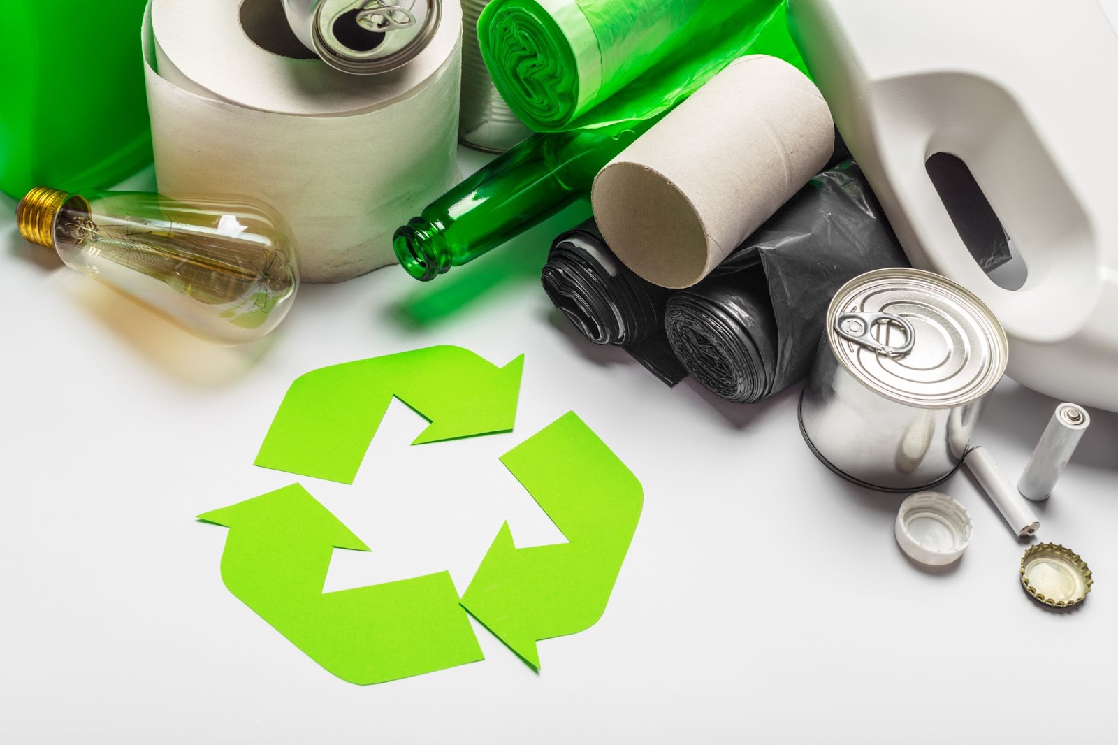 Recycling symbol next to metal and plastic recyclables. 