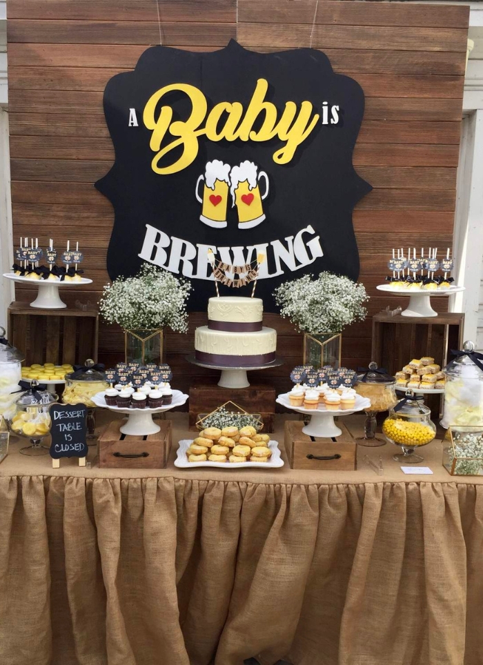baby is brewing sign hanging over food table