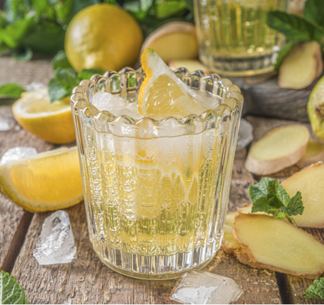 ginger lemonade in a sort glass with ice and a lemon garnish